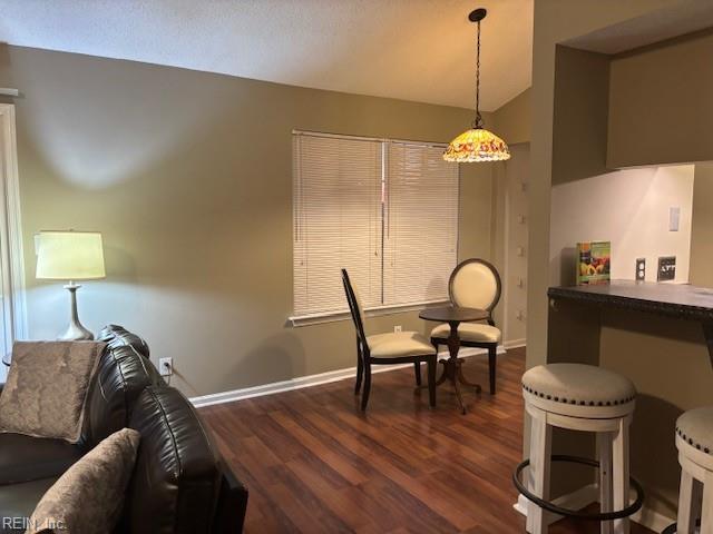 dining space featuring vaulted ceiling and dark hardwood / wood-style floors