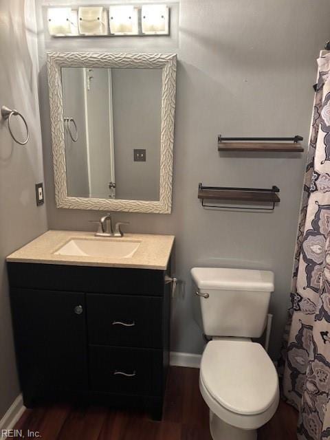 bathroom featuring wood-type flooring, vanity, and toilet