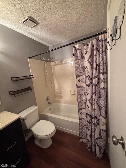 full bathroom featuring shower / bathtub combination with curtain, hardwood / wood-style floors, vanity, a textured ceiling, and toilet