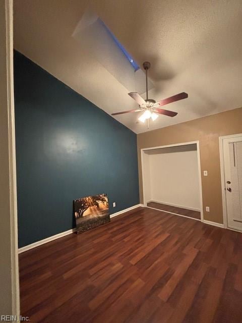 unfurnished bedroom with dark hardwood / wood-style flooring, lofted ceiling, and ceiling fan