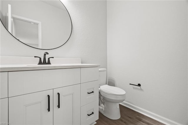 bathroom featuring wood-type flooring, toilet, and vanity