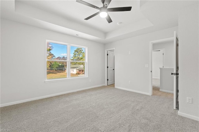 interior space featuring a raised ceiling and ceiling fan