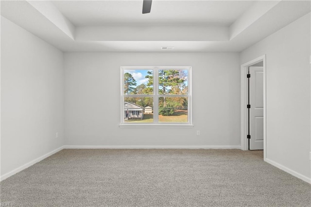 carpeted spare room with a tray ceiling