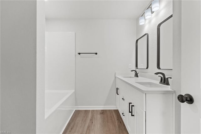 bathroom with wood-type flooring, bathtub / shower combination, and vanity