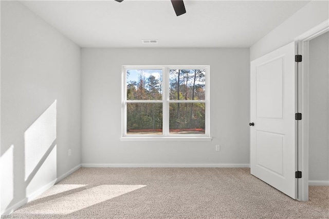 carpeted spare room featuring ceiling fan