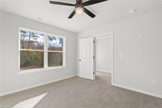 spare room featuring ceiling fan and carpet