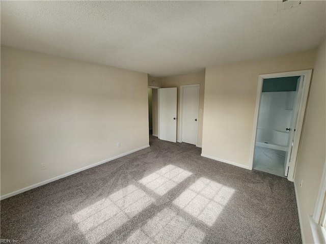 unfurnished bedroom with connected bathroom, carpet floors, and a textured ceiling