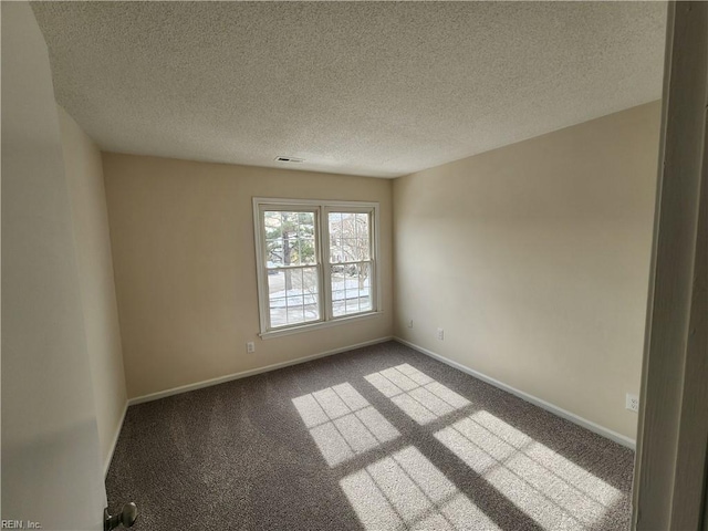 carpeted spare room with a textured ceiling