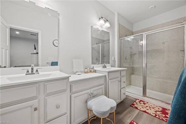 bathroom featuring hardwood / wood-style flooring, vanity, and a shower with door