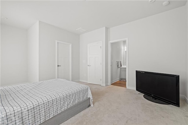 carpeted bedroom featuring ensuite bath