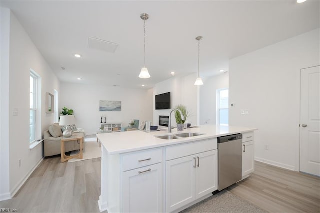 kitchen with sink, white cabinetry, decorative light fixtures, dishwasher, and an island with sink