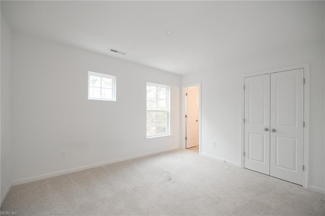 unfurnished bedroom featuring light carpet