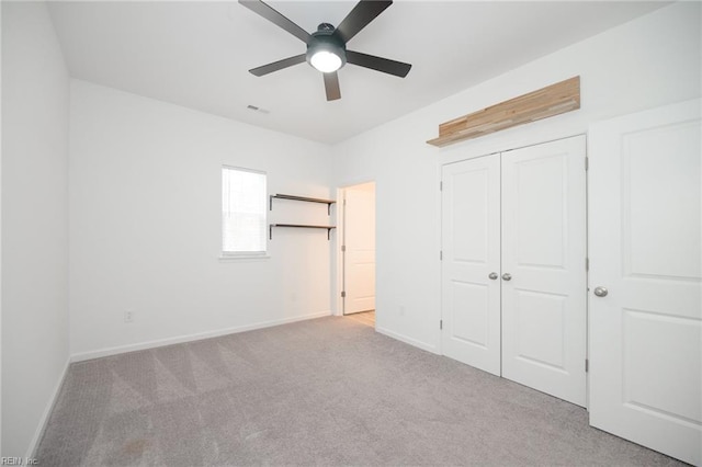 unfurnished bedroom featuring light colored carpet, ceiling fan, and a closet