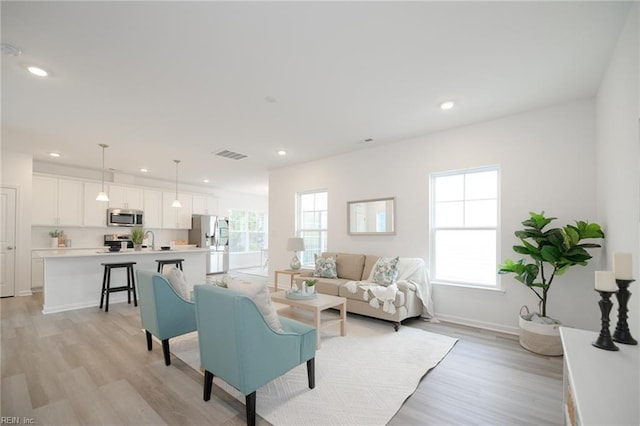 living room with sink and light wood-type flooring