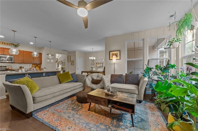 living room featuring ceiling fan with notable chandelier