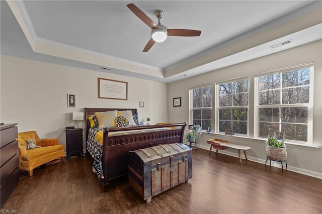 bedroom featuring dark wood-type flooring, ceiling fan, and a tray ceiling