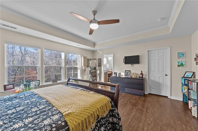 bedroom featuring crown molding, ceiling fan, dark hardwood / wood-style flooring, and a raised ceiling