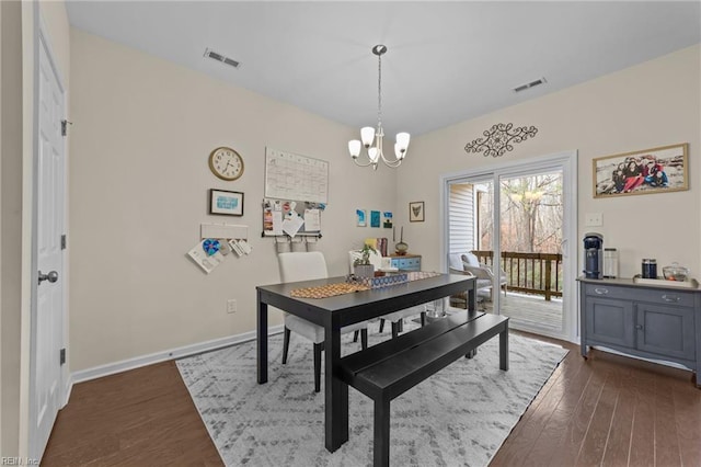 dining space featuring an inviting chandelier and dark wood-type flooring