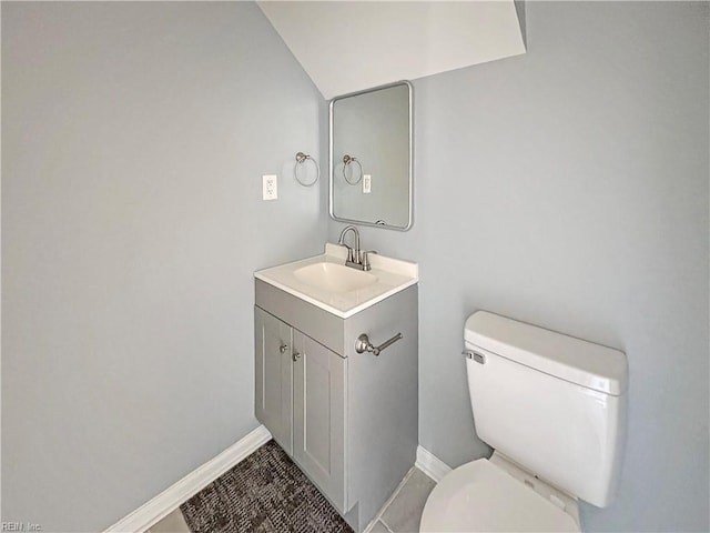 bathroom featuring vanity, lofted ceiling, and toilet