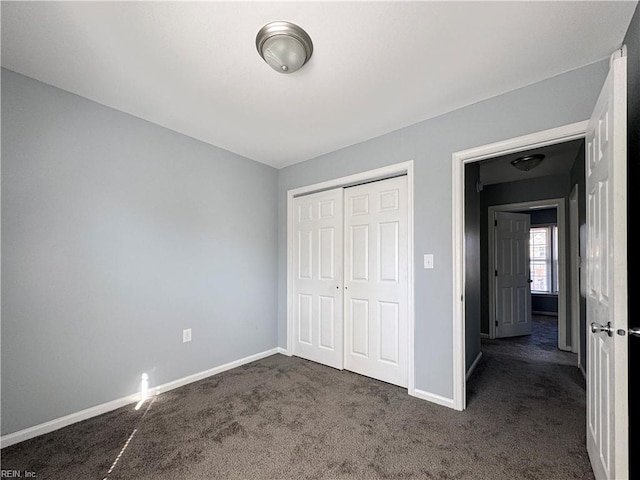 unfurnished bedroom featuring a closet and dark colored carpet