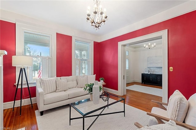 living room with hardwood / wood-style flooring and a notable chandelier