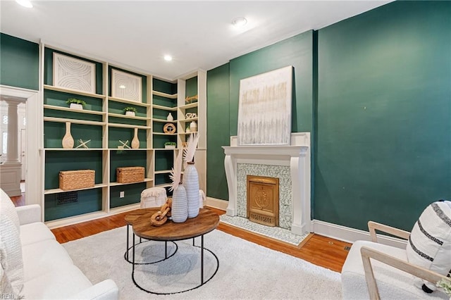 sitting room with wood-type flooring and ornate columns