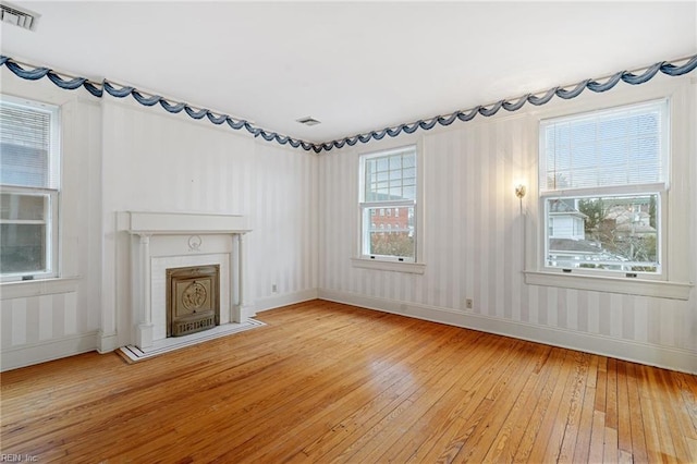 unfurnished living room with wood-type flooring and plenty of natural light