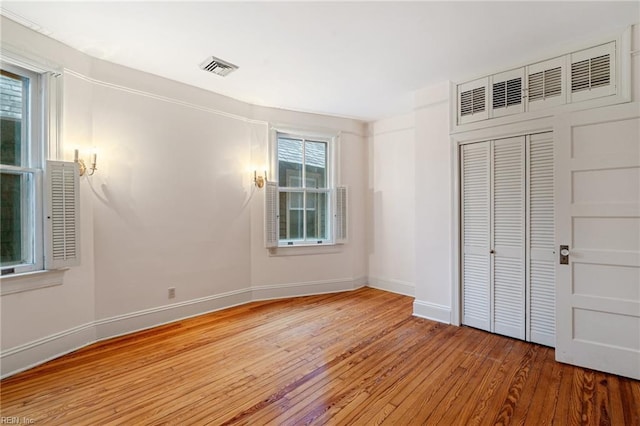 unfurnished bedroom with light hardwood / wood-style floors and a closet