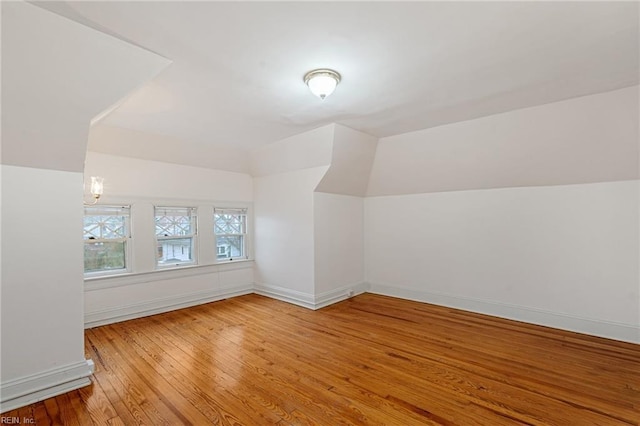 bonus room with lofted ceiling and hardwood / wood-style flooring