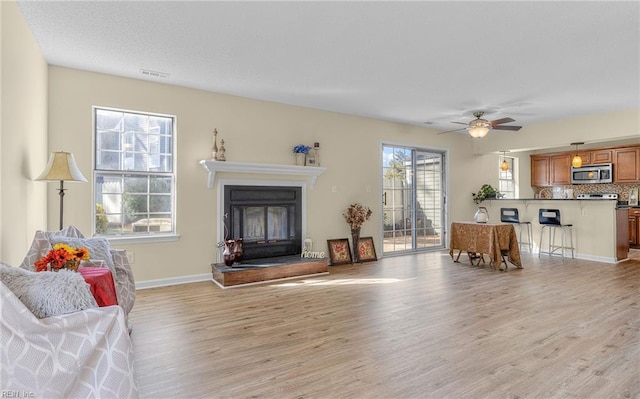 living room with ceiling fan and light hardwood / wood-style floors