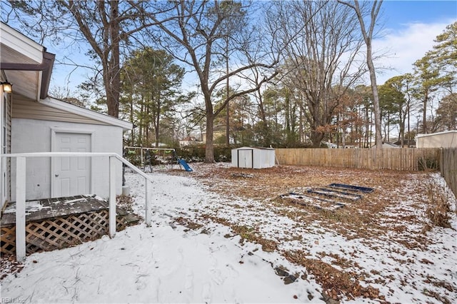 yard covered in snow with a shed and a playground