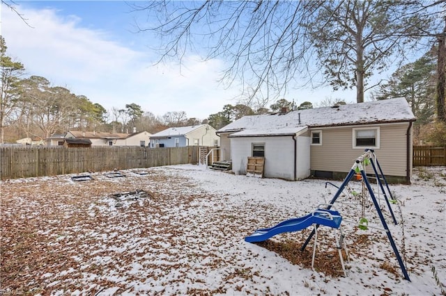 snow covered house featuring a playground