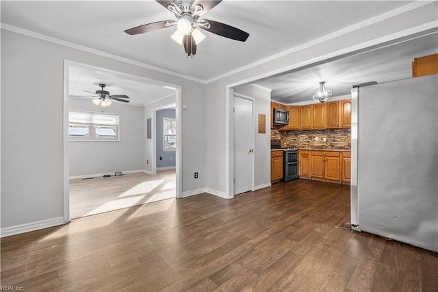 kitchen with tasteful backsplash, crown molding, appliances with stainless steel finishes, and hardwood / wood-style flooring