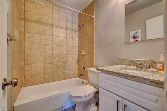 full bathroom featuring tiled shower / bath combo, vanity, and toilet