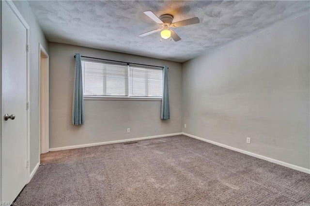 carpeted spare room featuring a textured ceiling and ceiling fan