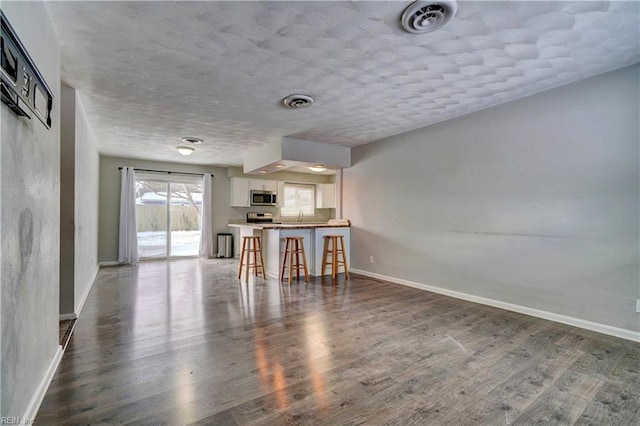 unfurnished living room with dark hardwood / wood-style floors and a textured ceiling