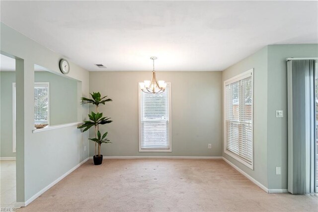 carpeted spare room featuring a chandelier