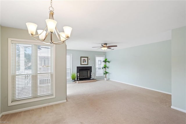 unfurnished living room with light carpet and ceiling fan with notable chandelier