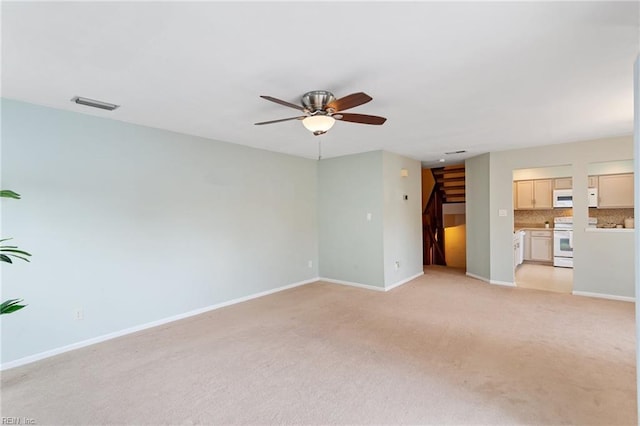 unfurnished living room with ceiling fan and light colored carpet