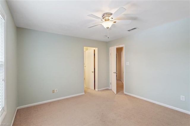 carpeted spare room with ceiling fan