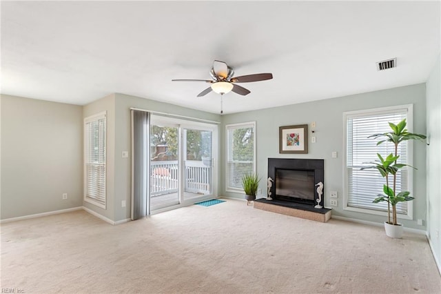 unfurnished living room with plenty of natural light, light colored carpet, and ceiling fan