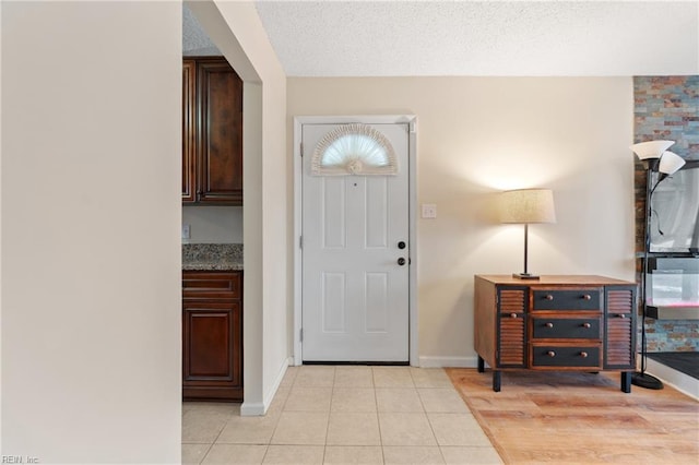 tiled entrance foyer featuring a textured ceiling