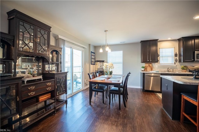 dining area with sink, dark wood-type flooring, and a healthy amount of sunlight