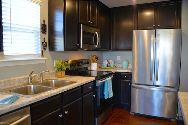 kitchen with dark hardwood / wood-style flooring, sink, dark brown cabinetry, and appliances with stainless steel finishes