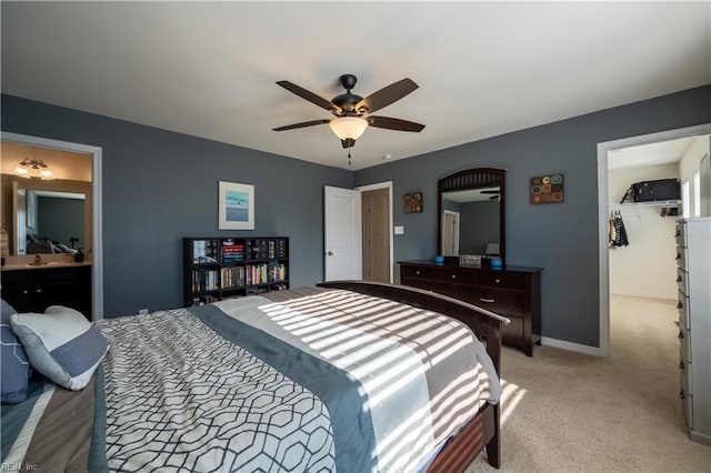 carpeted bedroom featuring ceiling fan, ensuite bath, a spacious closet, and a closet