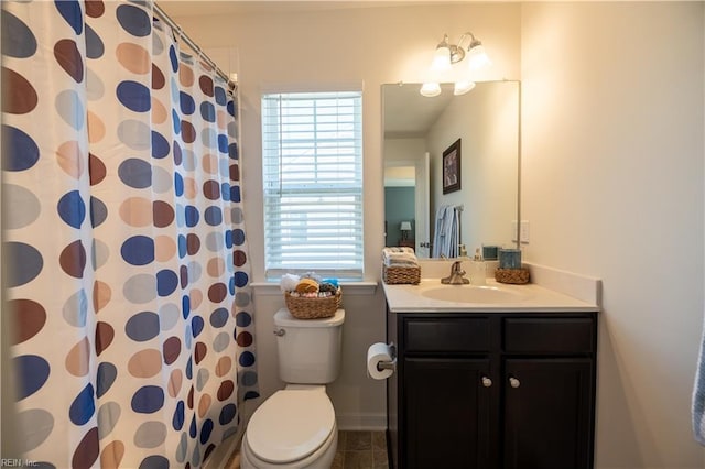 bathroom with walk in shower, vanity, toilet, and a wealth of natural light