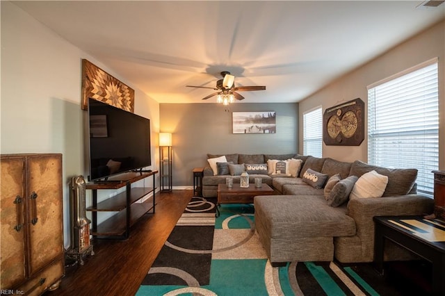 living room featuring ceiling fan and dark hardwood / wood-style flooring