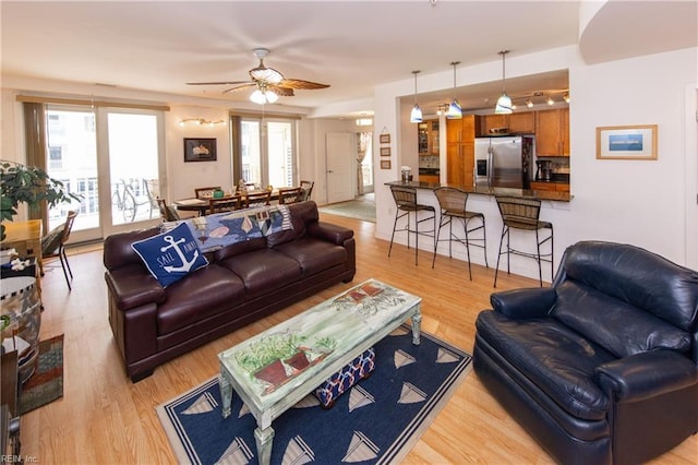 living room featuring light hardwood / wood-style floors and ceiling fan