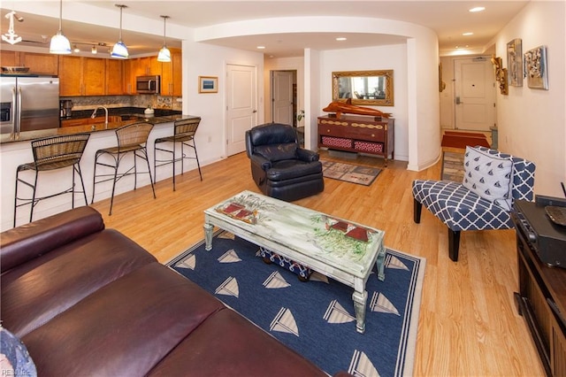 living room with sink and light hardwood / wood-style floors