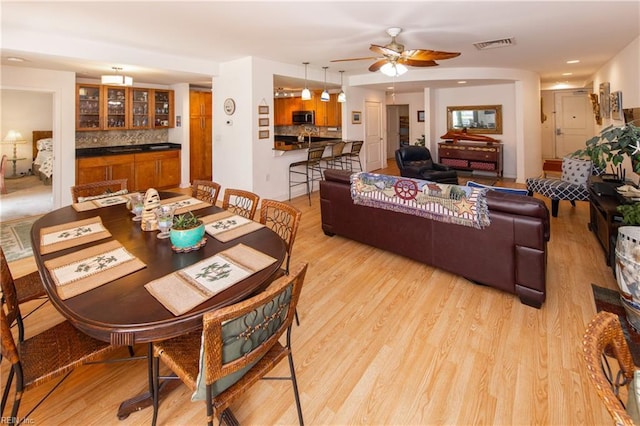 dining space featuring ceiling fan and light wood-type flooring